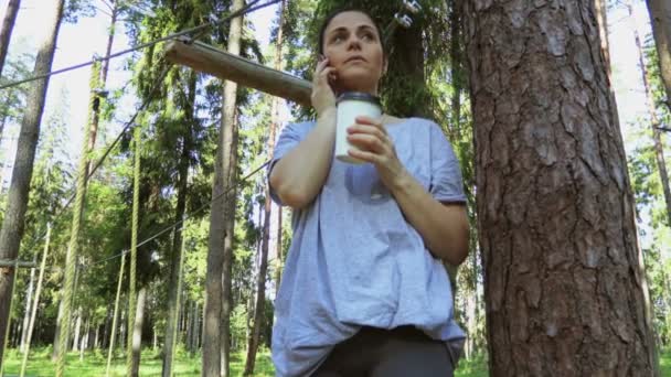 Γυναίκα Πίνουν Καφέ Και Χρήση Smartphone Στο Πάρκο Σχοινί Εμπόδια — Αρχείο Βίντεο