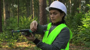 Kadın İşçi İHA Quadcopter 'ı video orman denetimi için hazırlıyor