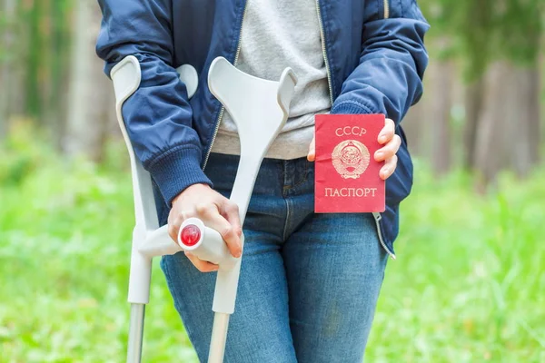 Injured Female With Crutches holding soviet union passport