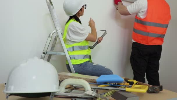 Mulher Trabalhador Construção Escrevendo Perto Parede — Vídeo de Stock