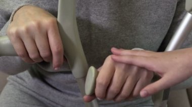 Çocuk elleri koltuk değnekleriyle engelli anne ellerine