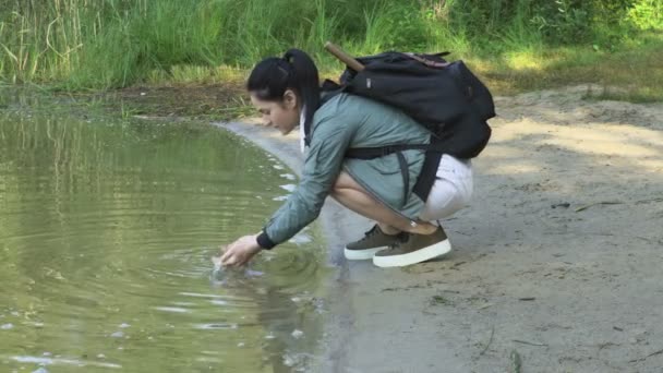 Mulher Caminhante Com Mochila Lavar Mãos Lago — Vídeo de Stock