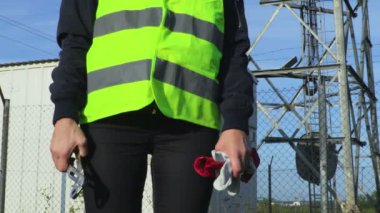 Tel örgülerin yanında koruyucu eldivenleri ve aletleri olan bir kadın işçi.