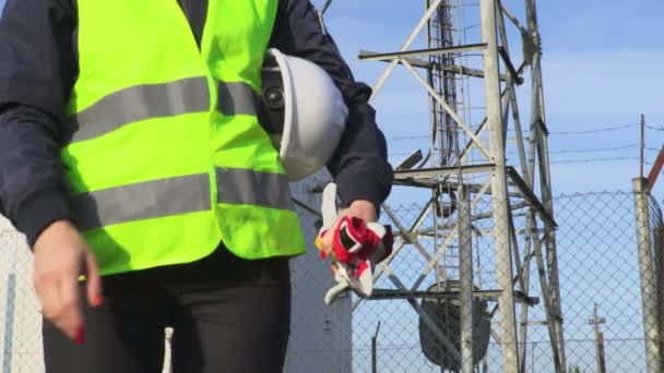 在无线通信塔天线附近手持防护头盔和工具的女工程师 通信和连接概念 — 图库视频影像