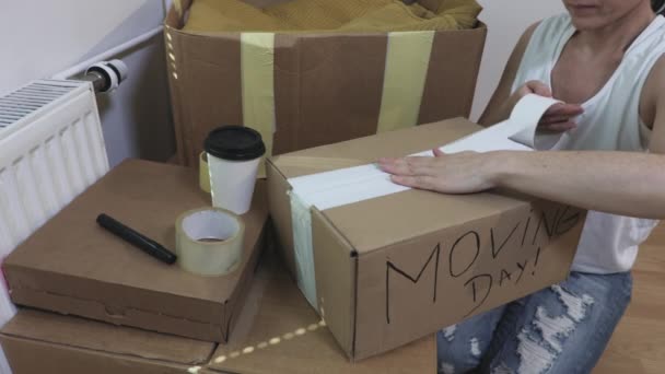 Жінка Закінчує Упаковку Словами Moving Day — стокове відео