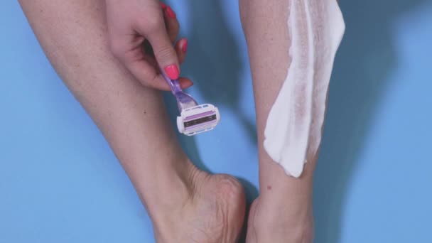 女性シェービング彼女の足上の青 — ストック動画