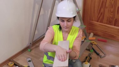 Kadın müteahhit panoyu kontrol ediyor ve başparmağını gösteriyor 