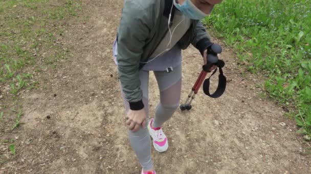 Mujer Con Mascarilla Protectora Sosteniendo Trekking Palos Sentir Dolor Rodilla — Vídeo de stock