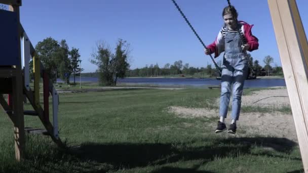 Glückliches Mädchen Schaukelt Auf Spielplatz — Stockvideo