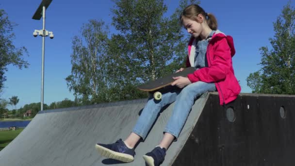 Girl Sitting Ramp Holds Hands Skateboard — Stock Video