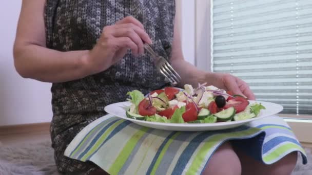 食べる前にギリシャのサラダを混ぜる女性 — ストック動画