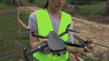 Kadın işçi uçmadan önce dronu kontrol ediyor