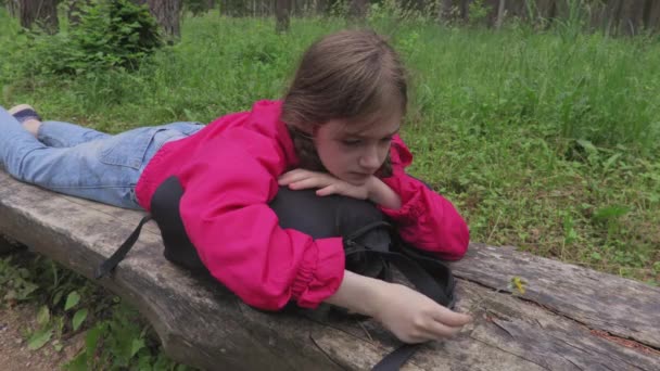 孤独な女の子とともにバックパックオンベンチで公園 — ストック動画