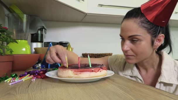 在芝士蛋糕上放生日蜡烛的女人 — 图库视频影像
