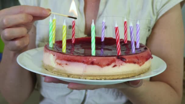 ケーキの上に誕生日のチーズケーキと照明キャンドルを持っている女性 — ストック動画