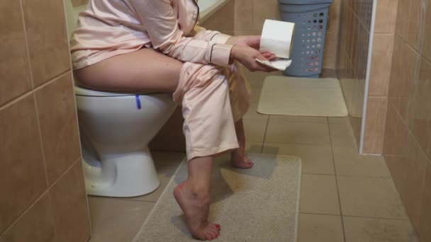 Mujer Sentada Inodoro Sosteniendo Papel Higiénico — Vídeos de Stock