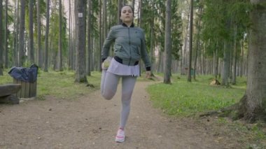 Park yolunda koşan ve esneyen bir kadın. Sağlıklı yaşam tarzı kavramı.