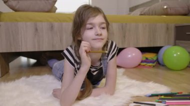 Küçük kız çizim yapmayı düşünüyor.