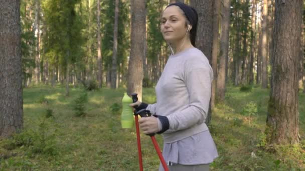 Vrouw Met Wandelstokken Ontspannen Bospad — Stockvideo