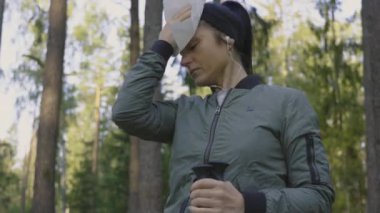 Yürüyüşten sonra peçete kullanan bir kadın.