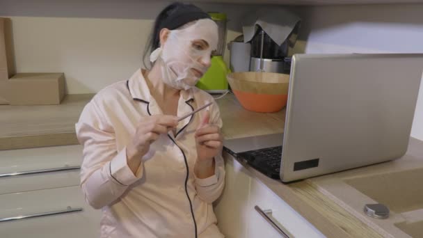 Kvinna Med Ansiktsmask Gör Manikyr Och Gör Videosamtal — Stockvideo