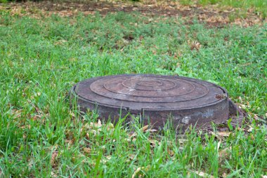 Çim, çim Park arka plan üzerinde metal su kapağı