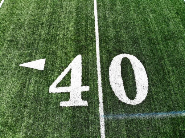 40 yard chalk mark on an green American football field taken from an aerial drone