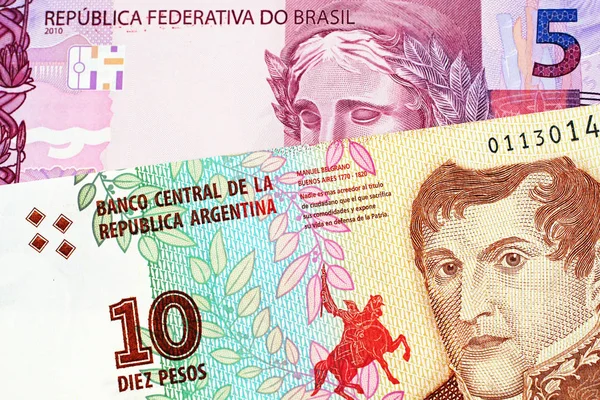 一个红色的巴西五雷亚尔纸币与阿根廷十比索钞票的宏观图像 — 图库照片