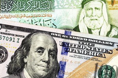Ürdün Dinarı bir fatura ile mavi bir Amerikan yüz dolarlık banknot bir makro görüntüsünü