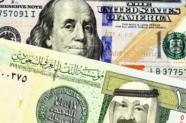 Görüntü mavi bir Amerikan yüz dolarlık banknot ve Suudi Arabistanlı bir Arabistan Riyali Not yakından