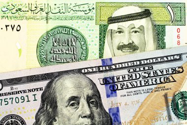 Görüntü mavi bir Amerikan yüz dolarlık banknot ve Suudi Arabistanlı bir Arabistan Riyali Not yakından