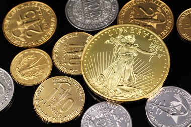 Batı Afrika Frangı sikke ve Amerikan altın bir ons sikke yansıtıcı siyah arka plan üzerinde bir ürün yelpazesine bir makro görüntüsünü