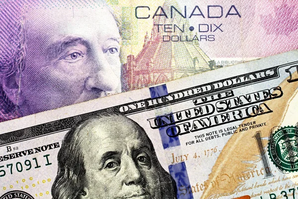 A purple Canadian ten dollar bill paired with a blue American one hundred dollar bill