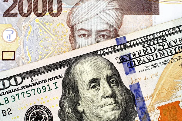 一张蓝色的美国100美元钞票和两千张印尼盾钞票关闭 — 图库照片
