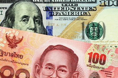 İmgae bir kırmızı yüz Tayland Bahtı makroda bir Amerikan yüz dolarlık banknot ile yakından