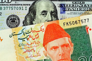 Pakistan 'dan yirmi Rupisi banka notu bir makro görüntü bir Amerikan 100 dolarlık fatura ile yakın