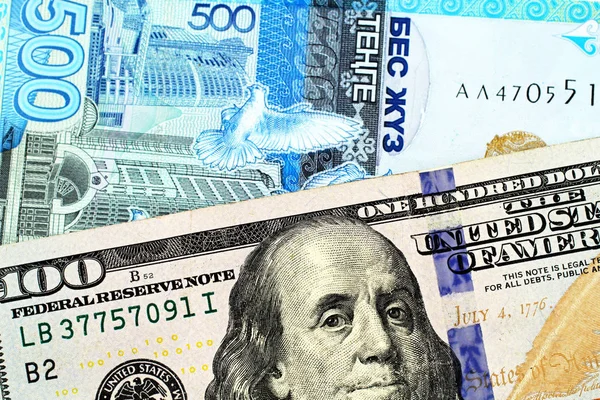 一张100美元的美国钞票与哈萨克斯坦的一张500坚戈钞票在宏观上紧随其后 — 图库照片