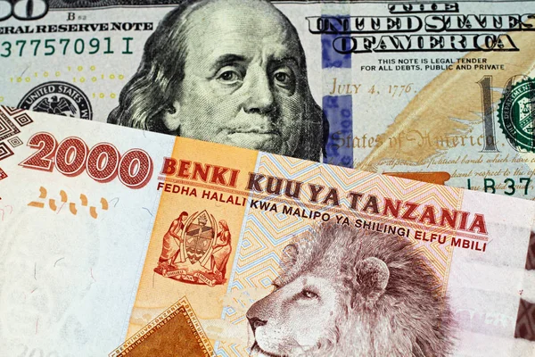 一张橙色和蓝色的两千坦桑尼亚先令钞票 带有美国蓝色 美国一百美元的钞票 — 图库照片