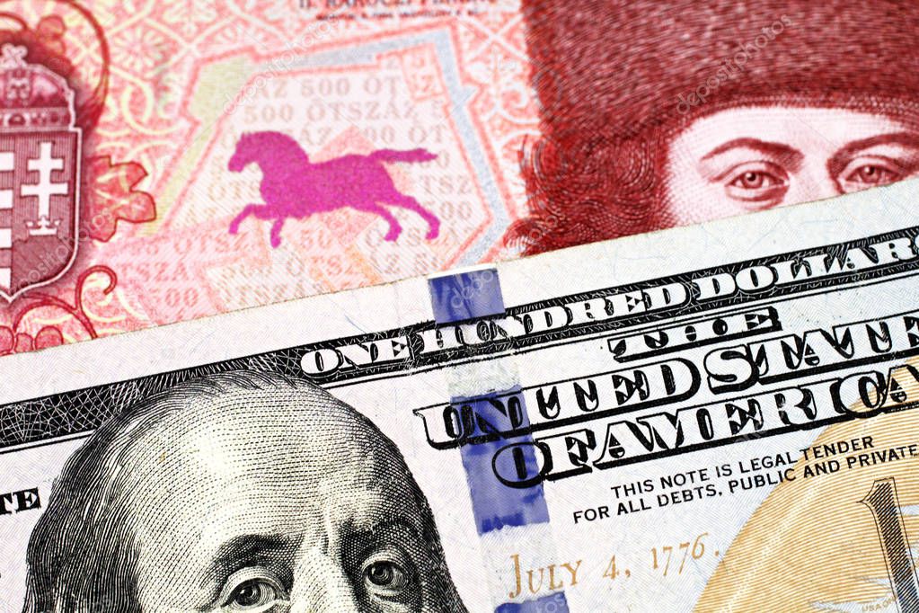 A red, five hundred Hungarian forint bank note with a blue American one hundred dollar bill close up in macro