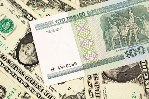 ベラルーシからの緑色の100ルーブル紙幣は アメリカの1ドル紙幣のベッドの上でマクロでクローズアップ — ストック写真