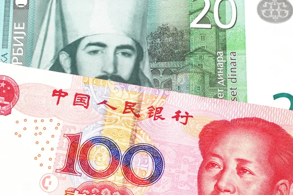 A twenty Serbian dinar bank note, close up in macro with a red Chinese one hundred yuan renminbi bank note