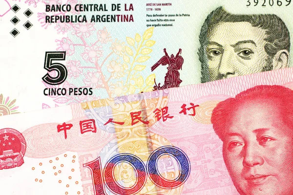 一张来自阿根廷的五比索钞票 以一张红色 一百元人民币钞票特写 — 图库照片
