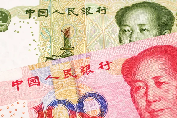 A close up image of a one yuan note from the People\'s Republic of China along with a red, one hundred yuan note from China