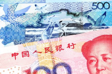 Çin Halk Cumhuriyeti'nden kırmızı, yüz yuan lık bir banknot, Kazakistan'dan gelen mavi, beş yüz tenge banknotla eşleştirilmiş.
