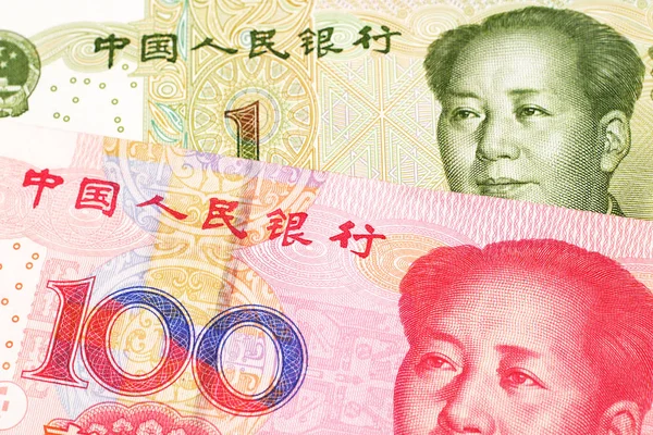 A close up image of a one yuan note from the People\'s Republic of China along with a red, one hundred yuan note from China
