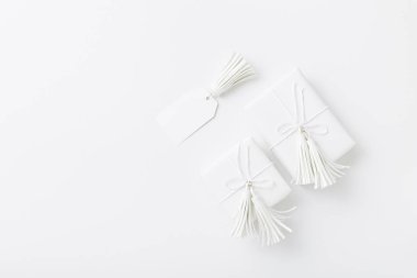 Beyaz püsküller ile sarılmış beyaz arka plan üzerinde beyaz Noel veya düğün hediyeleri