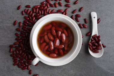 Beton masada beyaz fincan tatlı haşlanmış kırmızı fasulye.