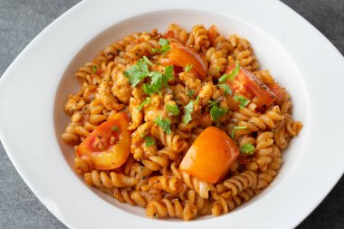 Concr üzerinde beyaz çanak tavuk ile sos domates Spiral makarna