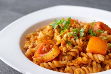 Concr üzerinde beyaz çanak tavuk ile sos domates Spiral makarna