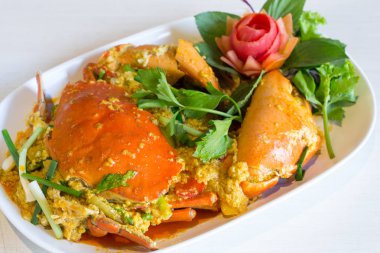 Toz köri ve masada beyaz tabak kızarmış yumurta ile tavada kızartılmış Yengeç.